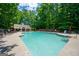 Large community pool surrounded by lounge chairs, tables, and umbrellas for a relaxing summer experience at 1130 S Rudder Rd, Cumming, GA 30041