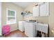 Functional laundry room with washer, dryer, utility sink, and storage cabinets at 1130 S Rudder Rd, Cumming, GA 30041