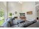 A living room with a cozy fireplace, tall ceilings, a ceiling fan, and a grey L-shaped couch at 1130 S Rudder Rd, Cumming, GA 30041
