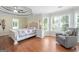 Spacious main bedroom with a tray ceiling, hardwood floors, and natural light from the windows at 1130 S Rudder Rd, Cumming, GA 30041