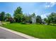 Expansive lawn surrounds this home with mature trees, a long driveway, and a partial view of the home's side at 1130 S Rudder Rd, Cumming, GA 30041