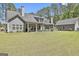 Spacious backyard featuring a covered porch, well-maintained lawn, and a detached garage at 120 Laurel Forest Dr, Tyrone, GA 30290