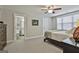Spacious bedroom features neutral carpet, ceiling fan, ensuite bath, and ample natural light through the windows at 120 Laurel Forest Dr, Tyrone, GA 30290