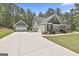 Exterior shot showcasing home's detached garage and expansive concrete driveway at 120 Laurel Forest Dr, Tyrone, GA 30290