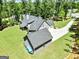 Rear aerial view of a home with a long driveway and matching detached garage at 120 Laurel Forest Dr, Tyrone, GA 30290
