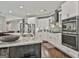 Kitchen features stainless steel appliances, white cabinets, an island, and gray tile backsplash at 120 Laurel Forest Dr, Tyrone, GA 30290