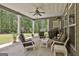 Outdoor patio with fan, plenty of seating, and a grill overlooking the lawn at 120 Laurel Forest Dr, Tyrone, GA 30290