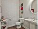 Stylish powder room featuring patterned wallpaper, wood flooring and a pedestal sink at 120 Laurel Forest Dr, Tyrone, GA 30290