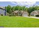 Exterior view of a home showcasing a well-maintained lawn, mature trees, and inviting curb appeal at 411 Baneberry Bnd, Peachtree City, GA 30269