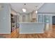 Open-concept kitchen with an eat-in island, stainless steel appliances, and easy access to the front entrance of the home at 411 Baneberry Bnd, Peachtree City, GA 30269