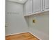 The laundry room features white cabinets above hook racks and laminate flooring at 411 Baneberry Bnd, Peachtree City, GA 30269