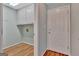 Bright laundry room with overhead cabinets, washer-dryer hookup, and wood-look flooring at 411 Baneberry Bnd, Peachtree City, GA 30269