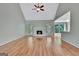 Open-concept living room featuring hardwood floors, a fireplace, and seamless access to the kitchen at 411 Baneberry Bnd, Peachtree City, GA 30269