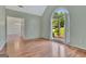 Bright living room featuring wood floors and large arch window overlooking landscaped front yard at 411 Baneberry Bnd, Peachtree City, GA 30269
