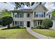 Charming two-story home with a landscaped yard, black shutters and a curved walkway leading to the front door at 1311 Bustling Sw Ln, Marietta, GA 30064
