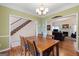 Light-filled dining room with hardwood floors, chandelier, and open layout to adjacent living spaces at 115 Roscommon Ct, Tyrone, GA 30290