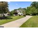 A well-maintained home with a long driveway surrounded by lush green lawn and mature trees at 115 Roscommon Ct, Tyrone, GA 30290