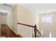 Upstairs hallway featuring wood floors, white trim and a view of the front entryway at 115 Roscommon Ct, Tyrone, GA 30290