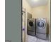Cozy laundry room with washer, dryer, shelving and tile floors at 115 Roscommon Ct, Tyrone, GA 30290