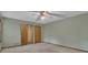 A cozy bedroom with plush carpet, ceiling fan, and convenient closet access at 886 Pine Needle Rd, Hampton, GA 30228