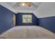 Cozy bedroom featuring navy blue walls, white ceilings, and a window with a backyard view at 886 Pine Needle Rd, Hampton, GA 30228