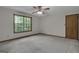 Bedroom featuring a ceiling fan, a window with a view, and neutral carpet at 886 Pine Needle Rd, Hampton, GA 30228