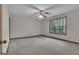 Spacious bedroom featuring a ceiling fan, a window with a view, and neutral carpet at 886 Pine Needle Rd, Hampton, GA 30228