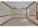 Formal dining room with classic chandelier, carpet, and wainscotting at 886 Pine Needle Rd, Hampton, GA 30228