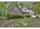 Attractive brick home features a manicured lawn, mature trees, and attached garage at 886 Pine Needle Rd, Hampton, GA 30228