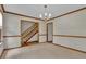 Traditional living room with neutral carpet, chandelier, and stairway access at 886 Pine Needle Rd, Hampton, GA 30228
