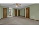 Spacious living room with soft green paint and neutral carpeting, offering multiple entry points at 886 Pine Needle Rd, Hampton, GA 30228