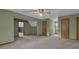 Spacious living room with soft green paint, featuring a ceiling fan and neutral carpeting at 886 Pine Needle Rd, Hampton, GA 30228