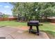 Backyard patio area with a BBQ grill, shed, and well-maintained lawn with wood privacy fence at 162 Aylesbury Blvd, Mcdonough, GA 30252