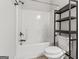 Clean bathroom featuring a shower-tub combo, toilet, and shelving unit at 162 Aylesbury Blvd, Mcdonough, GA 30252
