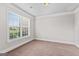 A cozy room with neutral carpet, crown molding, and a large window at 162 Aylesbury Blvd, Mcdonough, GA 30252