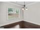 Bright dining room with dark wood floors, large window, and decorative chandelier at 162 Aylesbury Blvd, Mcdonough, GA 30252