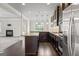 Open concept kitchen with dark wood cabinets, stainless steel appliances, granite countertops, and hardwood flooring at 162 Aylesbury Blvd, Mcdonough, GA 30252