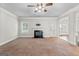Light-filled living room with a fireplace, two windows, ceiling fan, and access to outdoor space at 162 Aylesbury Blvd, Mcdonough, GA 30252