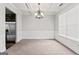 Living room with crown molding, neutral carpet, stainless fridge and a chandelier at 162 Aylesbury Blvd, Mcdonough, GA 30252