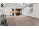 Open-concept living room, kitchen, and dining room view with a fireplace, staircase, and multiple windows at 162 Aylesbury Blvd, Mcdonough, GA 30252