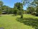 Spacious backyard features mature trees, offering a serene and private outdoor setting with plenty of room for activities at 18 North Ave, Hampton, GA 30228