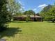 Lush backyard offers a serene view of the home's exterior, set within a green, well-maintained lawn at 18 North Ave, Hampton, GA 30228