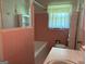 Charming bathroom with vintage pink tile and a tub shower at 18 North Ave, Hampton, GA 30228