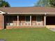 Close up shot of a charming single-story brick home with a quaint front porch at 18 North Ave, Hampton, GA 30228