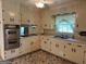 Charming kitchen with traditional cabinets, modern appliances, and cozy accents under a ceiling fan at 18 North Ave, Hampton, GA 30228