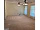Sunny living room featuring carpet, large windows with curtains, and stylish ceiling fans at 18 North Ave, Hampton, GA 30228