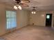 Bright and airy living room with large windows, carpet, and classic ceiling fans for comfortable living at 18 North Ave, Hampton, GA 30228