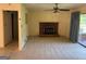 Cozy living room with a brick fireplace, neutral carpet, and sliding doors leading to an outdoor patio at 18 North Ave, Hampton, GA 30228