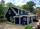 Rear exterior featuring dark blue siding with white trim, surrounded by lush landscaping at 209 Hearthstone Reach, Peachtree City, GA 30269