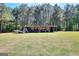 Open barn with supplies and trailer sitting on a lawn in front of a wooded area at 1621 Dixie Rd, Covington, GA 30014